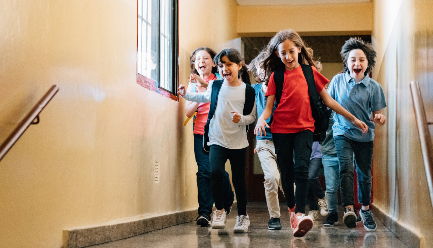 Skolēni laimīgi skrien pa skolas gaiteni